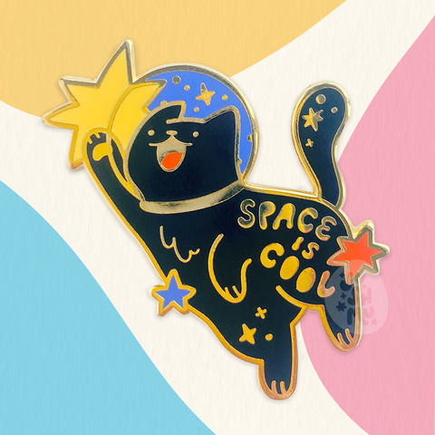 A black cat pin that says space is cool. Made by jushmu